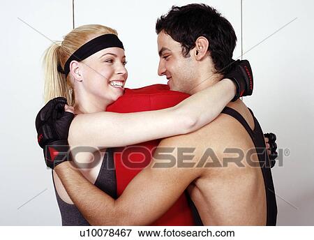 Stock Photo - Young man and woman flirting in a fitness class. Fotosearch