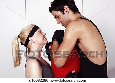 Stock Photograph - Young man and woman flirting in a fitness class. Fotosearch