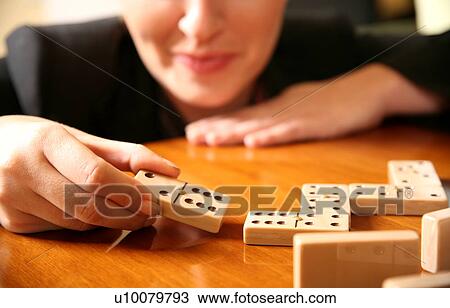Stock Image - A woman playing with dominoes. Fotosearch