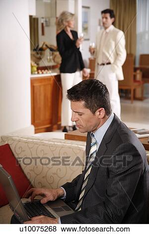 Bussinessman working on a laptop computer during meeting View Large Photo Image Stock Photo - Bussinessman working on a laptop computer during meeting. Fotosearch