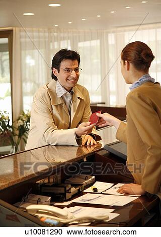Man checking in at the hotel reception desk View Large Photo Image Stock Image - Man checking in at the hotel reception desk. Fotosearch