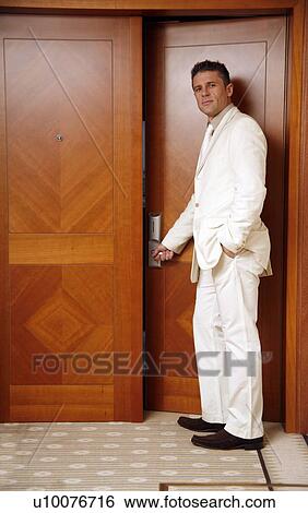 Stock Photograph - Man putting card key into hotel room door. Fotosearch