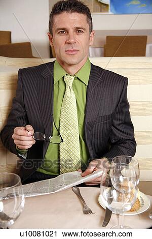 Man sitting at the table in a restaurant View Large Photo Image Stock Image - Man sitting at the table in a restaurant. Fotosearch