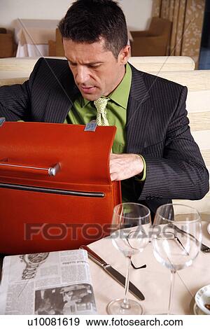 Stock Photo - Man sitting at the table in a restaurant. Fotosearch
