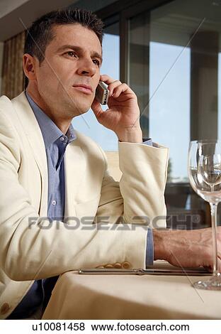 Man sitting in at the table in a restaurant View Large Photo Image Stock Photo - Man sitting in at the table in a restaurant. Fotosearch