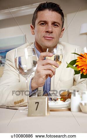 Man sitting in at the table in a restaurant View Large Photo Image Stock Photograph - Man sitting in at the table in a restaurant. Fotosearch