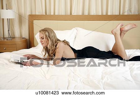 Woman relaxing in bed View Large Photo Image Stock Image - Woman relaxing in bed. Fotosearch