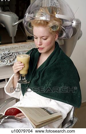 Young woman sitting under hairdryer View Large Photo Image Picture - Young woman sitting under hairdryer. Fotosearch
