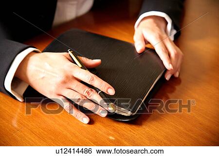 Stock Photograph - A woman holding an agenda book. Fotosearch