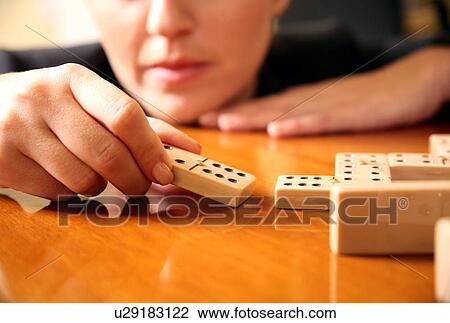 Stock Image -  A woman playing with dominoes. Fotosearch