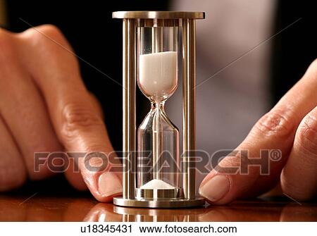 An hourglass held down with two fingers View Large Photo Image Stock Image - An hourglass held down with two fingers. Fotosearch
