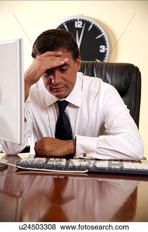 Businessman sitting at his desk lost in thought View Large Photo Image Stock Photo - Businessman sitting at his desk lost in thought. Fotosearch