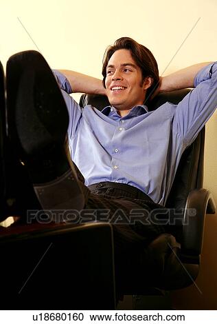 Young businessman relaxing with hands behind head View Large Photo Image Stock Image - Young businessman relaxing with hands behind head. Fotosearch