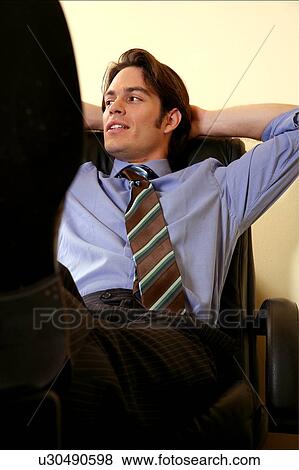 Young businessman relaxing with hands behind head View Large Photo Image Stock Photo - Young businessman relaxing with hands behind head. Fotosearch