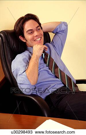 Young businessman sitting in chair and relaxing View Large Photo Image Stock Image - Young businessman sitting in chair and relaxing. Fotosearch
