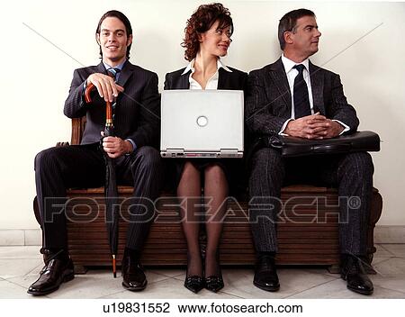 Stock Image - Three people sitting in a waiting room. Fotosearch