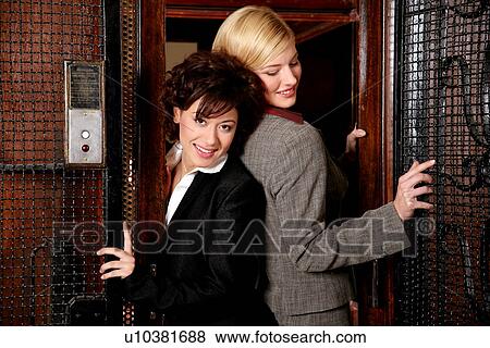 Two women exiting from an elevator View Large Photo Image Stock Photo - Two women exiting from an elevator. Fotosearch