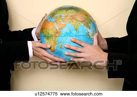 Two women holding a globe together View Large Photo Image Stock Photography - Two women holding a globe together. Fotosearch