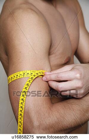 Stock Photography - Man measuring his arm muscle. Fotosearch