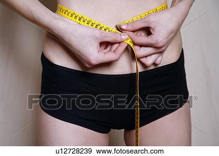 Man measuring his waist View Large Photo Image Stock Photo - Man measuring his waist. Fotosearch