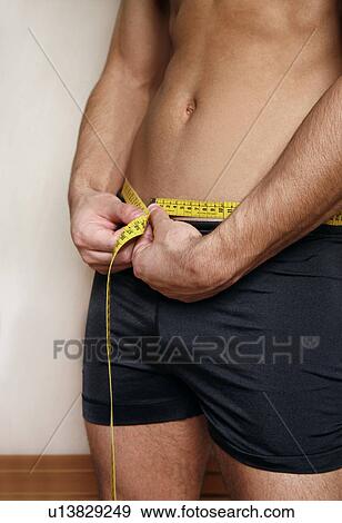 Man measuring his waist View Large Photo Image Stock Photo - Man measuring his waist. Fotosearch