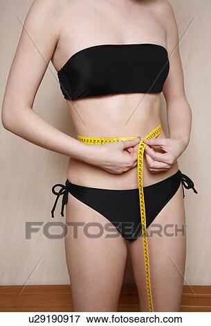Woman measuring her waist View Large Photo Image Stock Photo - Woman measuring her waist. Fotosearch