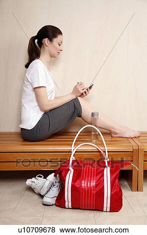 Stock Photo - Woman relaxing in locker room after the gym. Fotosearch