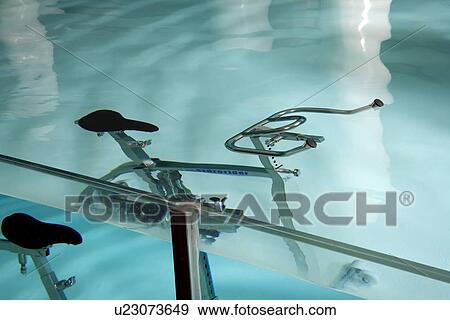 Stock Photo - An exercise bicycle in a swimming pool. Fotosearch