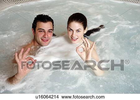 Picture - One man with two woman in jacuzzi at a spa. Fotosearch
