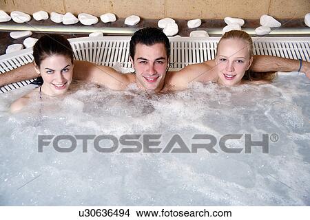 One man with two woman in jacuzzi at a spa View Large Photo Image Picture - One man with two woman in jacuzzi at a spa. Fotosearch
