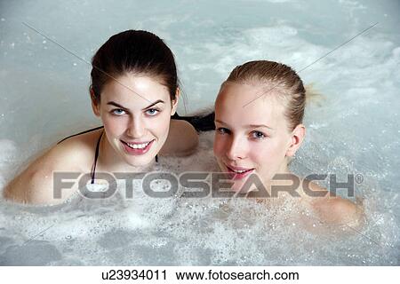 Stock Image - Two young woman in jacuzzi at a spa. Fotosearch