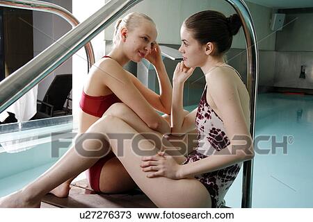 Two young woman sitting next to spa pool View Large Photo Image Stock Image - Two young woman sitting next to spa pool. Fotosearch
