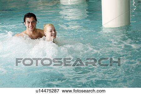 Stock Photo - Young couple swimming in spa pool. Fotosearch