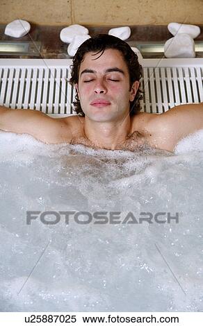 Stock Photography - Young man in jacuzzi at a spa. Fotosearch