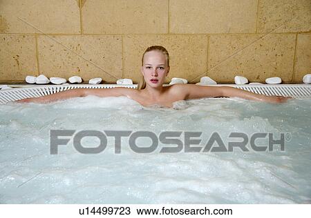 Stock Image - Young woman in jacuzzi at a spa. Fotosearch