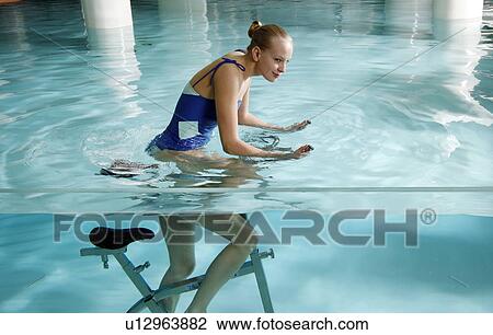 Young woman on exercise bike in spa pool View Large Photo Image Stock Image - Young woman on exercise bike in spa pool. Fotosearch