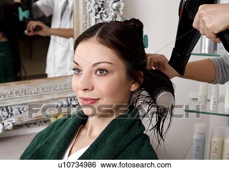 Stock Photograph - Young woman having her hair curled. Fotosearch