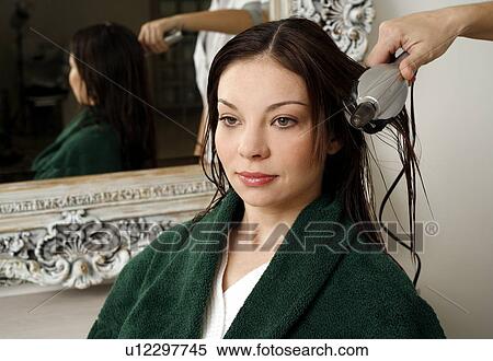 Stock Photography - Young woman having her hair curled. Fotosearch
