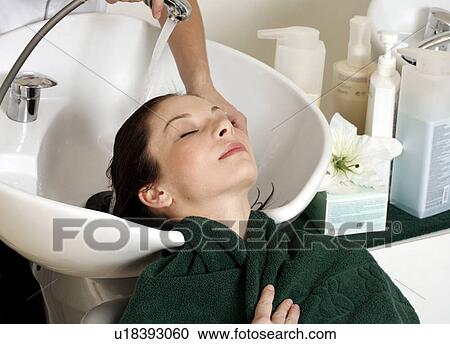 Young woman having her hair washed at a salon View Large Photo Image Stock Image - Young woman having her hair washed at a salon. Fotosearch