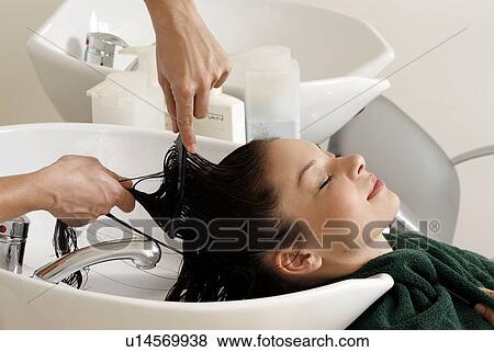Stock Photo - Young woman having her hair washed at a salon. Fotosearch