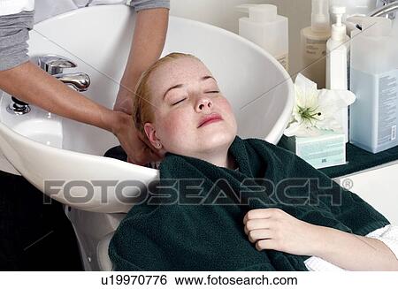 Young woman having her hair washed at a salon View Large Photo Image Stock Photograph - Young woman having her hair washed at a salon. Fotosearch
