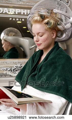 Young woman sitting under hairdryer View Large Photo Image Stock Image - Young woman sitting under hairdryer. Fotosearch