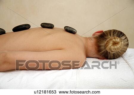 Young woman enjoying a hot stone massage View Large Photo Image Stock Image - Young woman enjoying a hot stone massage. Fotosearch