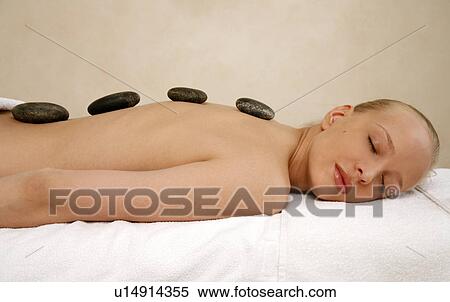 Young woman enjoying a hot stone massage View Large Photo Image Stock Photography - Young woman enjoying a hot stone massage. Fotosearch