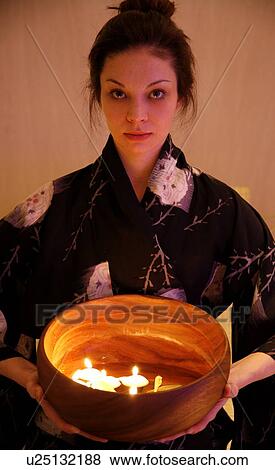Young woman holding wooden bowl with burning candles View Large Photo Image Stock Photo - Young woman holding wooden bowl with burning candles. Fotosearch