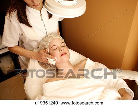 Stock Image - Woman having a facial treatment at a spa. Fotosearch