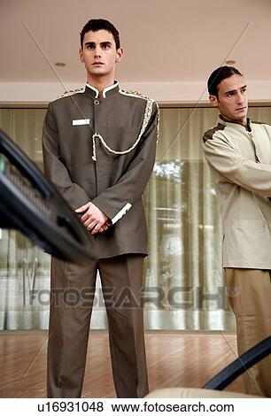 Bellboy delivering luggage to hotel with doorman standing by View Large Photo Image Stock Photo - Bellboy delivering luggage to hotel with doorman standing by. Fotosearch