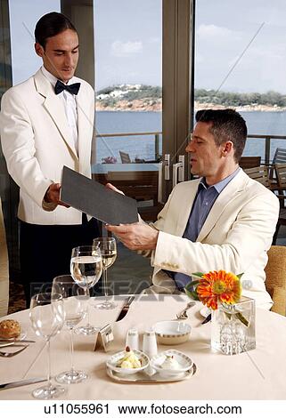 Waiter giving menu to customer in restaurant View Large Photo Image Stock Image - Waiter giving menu to customer in restaurant. Fotosearch