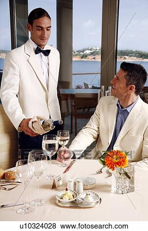 Stock Photo - Waiter serving customer in restaurant. Fotosearch