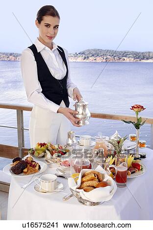 Stock Image - Waitress with breakfast table . Fotosearch